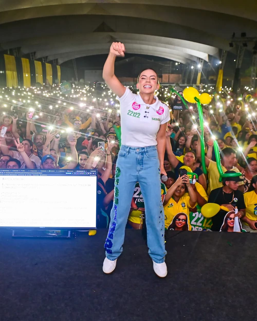 Débora Menezes no palco com a plateia de celulares acesos